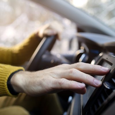 Közeli kép egy kézről az autoklímához nyúlva